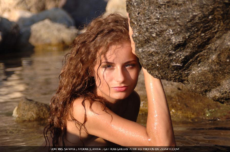 Red and curly girl sits naked on a sea stones - Juanita - 7