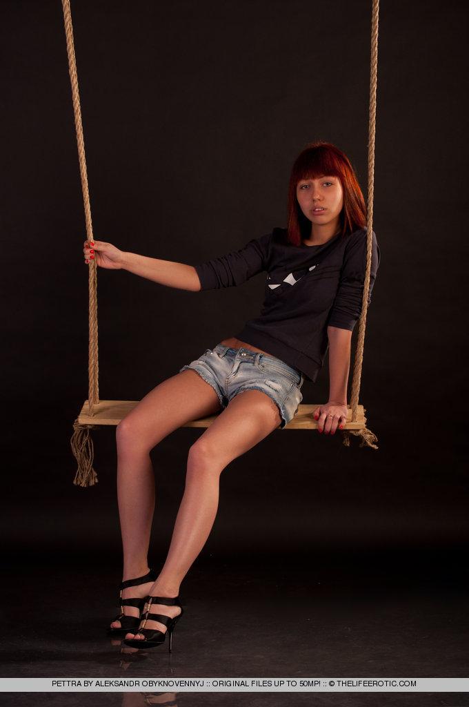 Young redhead shows pussy on the swing - Pettra - 1